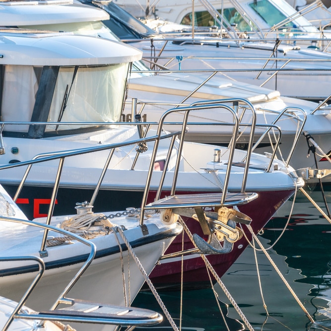White motorboats moored in a Coomera marina, reflected in calm water near Mortgage Broker Gold Coast.