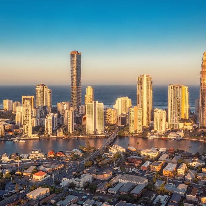 Aerial view of Gold Coast skyline with skyscrapers, riverside homes, and sunset sky—ideal for those seeking a mortgage adviser.